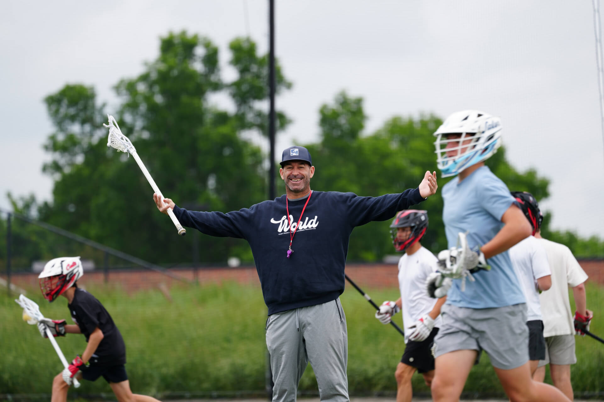 Casey Powell coaching young lacrosse players on the field